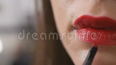 Vistaiste用红色唇膏涂抹一个女人的嘴唇